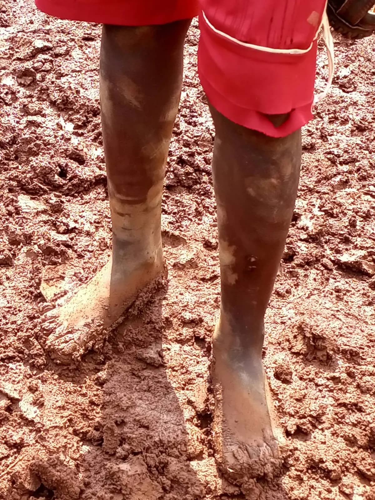 Bare feet in the red mud of the Kibagare pitch